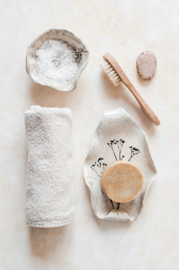white and brown wooden rolling skincare tools against marble surface