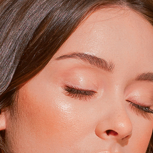 A close up of a woman's face and embroidered eyebrows