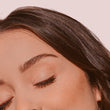 A close up of a woman's face with her eyes closed, focusing on her eyes and lash extensions